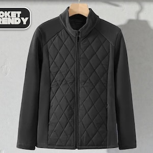 May include: Black quilted jacket with a full-length zipper and a stand-up collar. The jacket has a diamond pattern on the front and smooth panels on the sides and sleeves. The text "JACKET TRENDY" is in a black and white rectangle in the upper left corner.