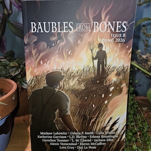 Puede incluir: Un libro de bolsillo titulado "BAUBLES FROM BONES" con una ilustración de portada dramática. La obra de arte representa a dos figuras en un campo con llamas y una horca. El número de la edición es 8, y la temporada es primavera de 2026. Los nombres de los autores se enumeran a continuación.