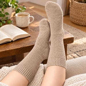 Può includere: Un paio di calze in maglia color beige con bordo a coste. Le calze sono realizzate con un filato testurizzato di medio spessore, arrivano a metà polpaccio e presentano tallone e punta rinforzati per una vestibilità comoda e aderente.