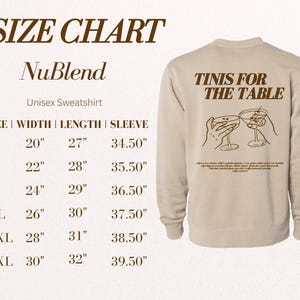 May include: A beige unisex sweatshirt with the text "TINIS FOR THE TABLE" printed on the back. The sweatshirt is a NuBlend brand and has a size chart with measurements in inches.