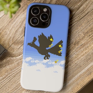 Op de afbeelding: Een blauwe en witte telefoonhoes met een gepixelde afbeelding van een zwarte vogel die in de lucht vliegt met gele sterren. De vogel vliegt boven witte wolken.