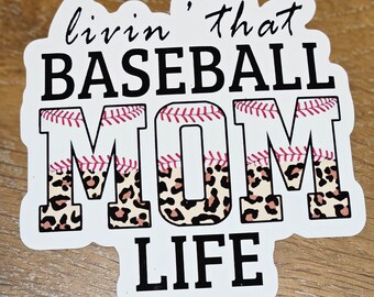 May include: A white sticker with black text that reads "livin' that BASEBALL MOM LIFE." The word "MOM" has a leopard print pattern. The letters in "BASEBALL" have a baseball stitch design.
