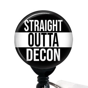 May include: Black and white badge reel with a round button that says "STRAIGHT OUTTA DECON".