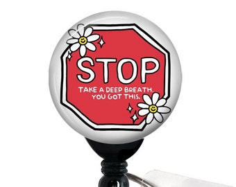 May include: A red stop sign with white lettering that reads "STOP" and "TAKE A DEEP BREATH, YOU GOT THIS."  The sign is decorated with white daisies and is attached to a black retractable badge reel.