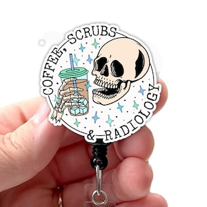 May include: A white round badge holder with a black retractable cord. The badge features a cartoon skull holding a cup of iced coffee with the text "Coffee, Scrubs & Radiology" around the image.