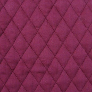 May include: Close-up of a quilted fabric with a diamond pattern. The fabric is a deep burgundy color, with visible stitching outlining each diamond. The texture appears soft and plush, suggesting a comfortable material.