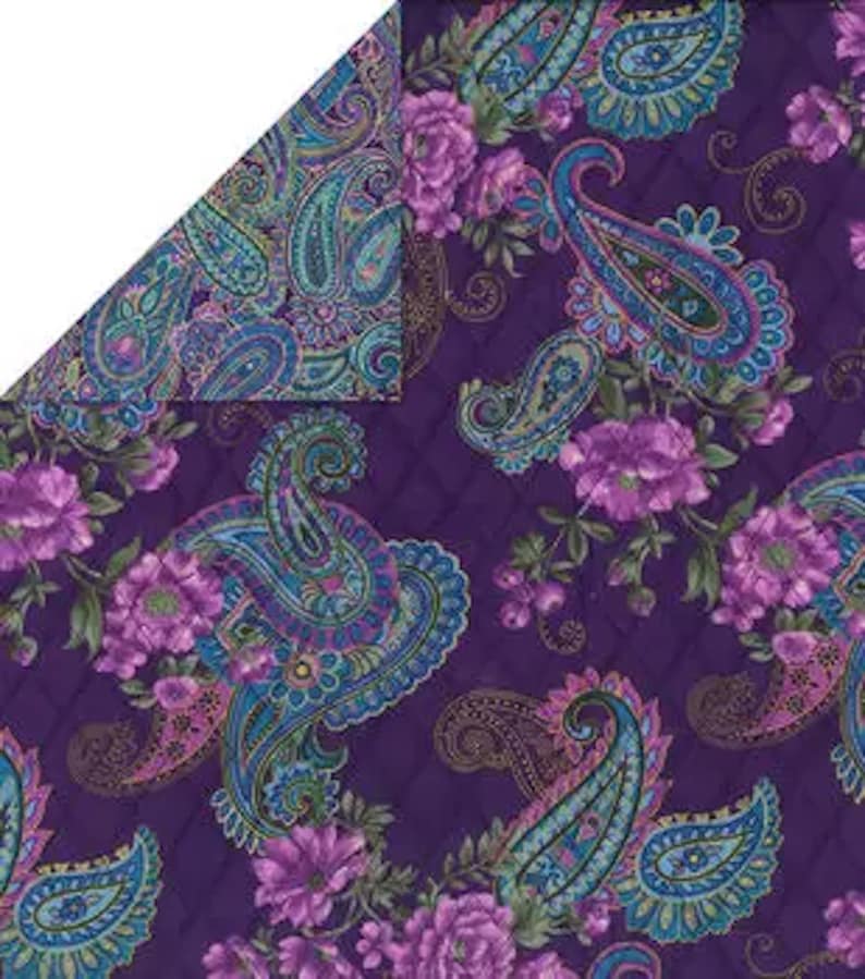 May include: A reversible textile with a paisley and floral pattern. One side features a deep purple quilted background with large paisley designs in teal, blue, and pink, interspersed with purple flowers. The reverse side has a similar paisley pattern on a teal background.