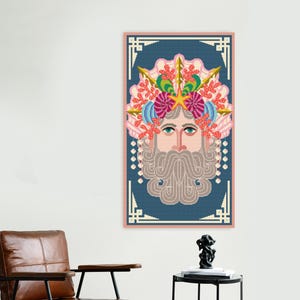 K&ouml;nnte beinhalten: Ein gerahmtes Kreuzstich-Kunstwerk mit einem stilisierten Gesicht mit langem, grauem Bart und einer farbenfrohen Krone aus Korallen und Muscheln. Das Kunstwerk ist vor einem blauen Hintergrund mit einem rosa Rahmen angeordnet.