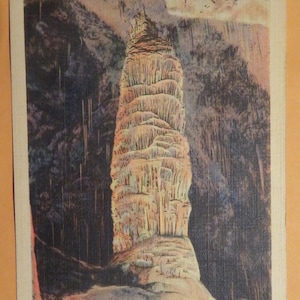 May include: A large, towering, white and yellow stalagmite formation in a cave. The caption reads "Giant Dome, World's Largest and Most Beautiful Stalagmite, Estimated Age 60,000,000 Years, Carlsbad Cavern National Park, New Mexico".