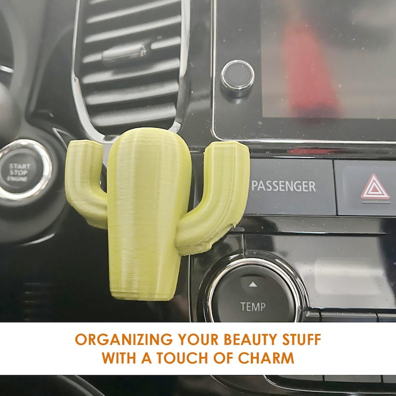 May include: A green cactus-shaped car air freshener hanging from the air vent of a car dashboard. The text "ORGANIZING YOUR BEAUTY STUFF WITH A TOUCH OF CHARM" is printed below the cactus.