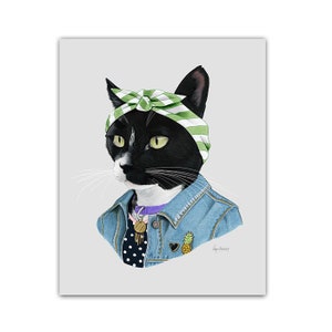Könnte beinhalten: Eine schwarz-weiße Katze trägt ein grün-weißes Bandana, eine Jeansjacke, ein lila Halsband mit einem goldenen Anhänger und ein schwarz-weißes gepunktetes Hemd. Die Katze schaut nach links.