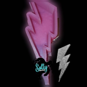 May include: A pink lightning bolt shaped silicone mold with a silver glitter lightning bolt on a black background. The mold is for making soap, resin, or other crafts. The text "Salty Creations" is visible in the image.