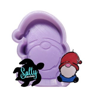 May include: Purple silicone mold of a gnome with a red hat and white beard. The mold is for making resin crafts. The mold is sitting on a white surface. The text "Salty Creations" is visible in the image.
