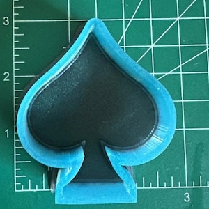 K&ouml;nnte beinhalten: Ein blauer Plastik-Ausstecher in Form eines Pik-Spielkartensymbols.
