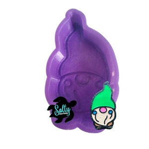 May include: Purple silicone mold for making gnome-shaped resin crafts. The mold is shaped like a gnome with a pointed hat and a beard. The mold is shown with a finished gnome resin craft.