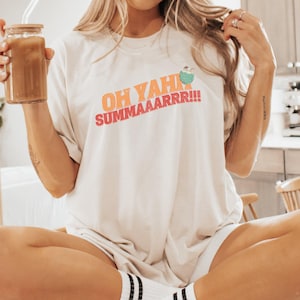 Puede incluir: Camiseta blanca con un estampado gráfico que dice "Oh yah summaaarrr!!" con un coco de dibujos animados y una pajita.