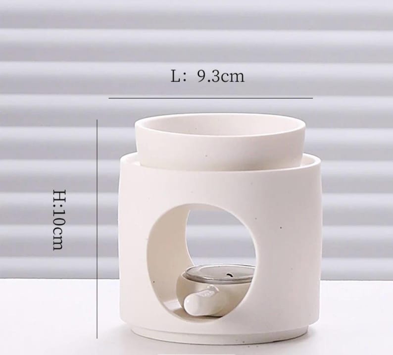May include: A white ceramic essential oil diffuser. The diffuser is cylindrical with a circular opening and a top bowl. It measures 3.7 inches in length and 3.9 inches in height. The text on the image reads: L: 9.3cm, H: 10cm.