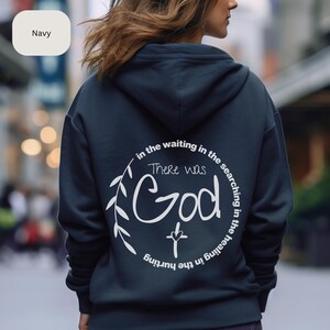 May include: Navy blue hoodie with a white graphic print that says "in the waiting in the searching in the healing in the hurting there was God" with a cross underneath the word God.