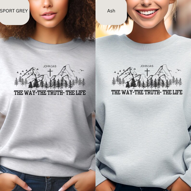 May include: A light gray sweatshirt with a mountain range and cross graphic. The text "JOHN 14:6" and "THE WAY-THE TRUTH-THE LIFE" are printed on the sweatshirt.