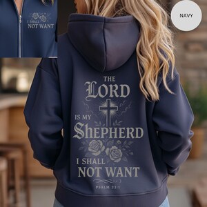 May include: Navy blue zip-up hoodie with the text "THE LORD IS MY SHEPHERD I SHALL NOT WANT" and a cross graphic on the back. The front of the hoodie has the text "I SHALL NOT WANT".