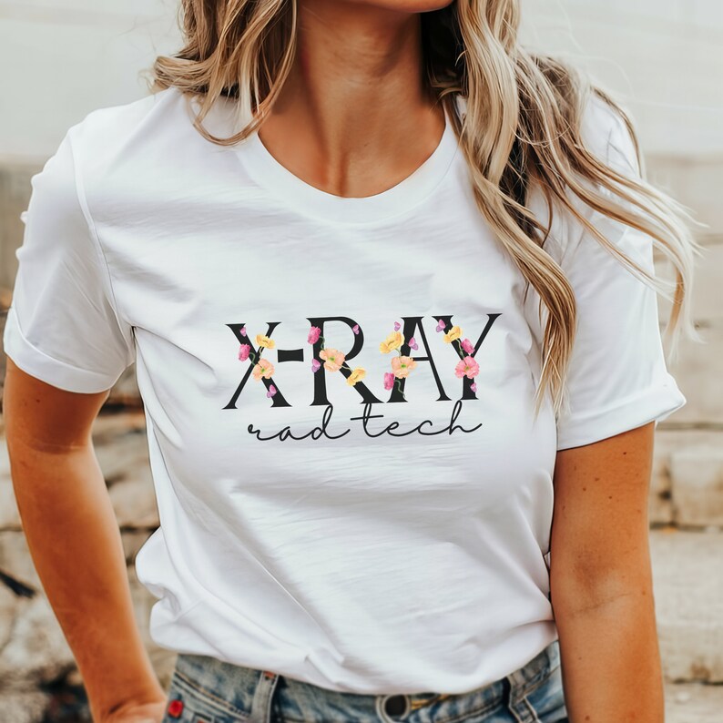 May include: White t-shirt with black text that reads "X-RAY rad-tech" with small floral accents.