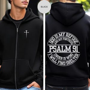 May include: Black zippered hoodie with a white cross on the front and a white circle on the back with the text "God is my refuge and my fortress Psalm 91 I will find shelter under his wing".