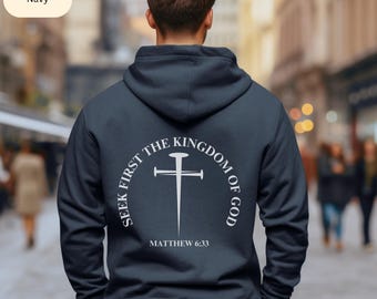 May include: Navy blue hoodie with a white graphic on the back. The graphic features a cross with a nail and the text "Seek First the Kingdom of God Matthew 6:33".