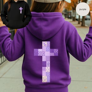 Puede incluir: Una sudadera con capucha morada con un diseño de cruz en la espalda, compuesta por varias telas florales y estampadas en tonos morados y lavanda. Se muestra una sudadera con capucha negra más pequeña con una cruz a juego. La palabra "purple" está en un círculo.
