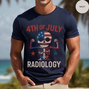 Op de afbeelding: Marineblauw t-shirt met een afbeelding van een skelet in rood, wit en blauw, ter viering van 4 juli. De tekst "4TH OF JULY" en "RADIOLOGY" staan op het shirt.