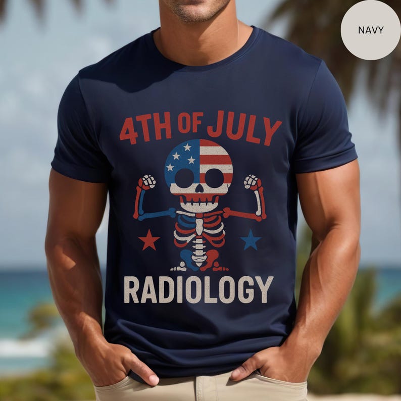 Op de afbeelding: Marineblauw t-shirt met een afbeelding van een skelet in rood, wit en blauw, ter viering van 4 juli. De tekst "4TH OF JULY" en "RADIOLOGY" staan op het shirt.