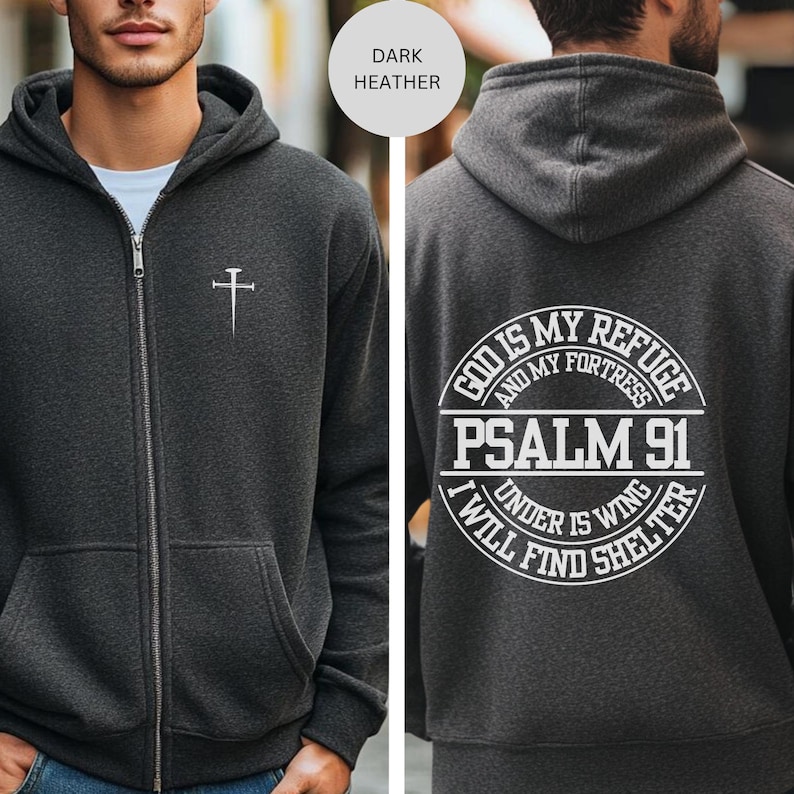 May include: Dark heather grey zippered hoodie with a cross on the front and the text "God is my refuge and my fortress Psalm 91 Under His wing I will find shelter" on the back.