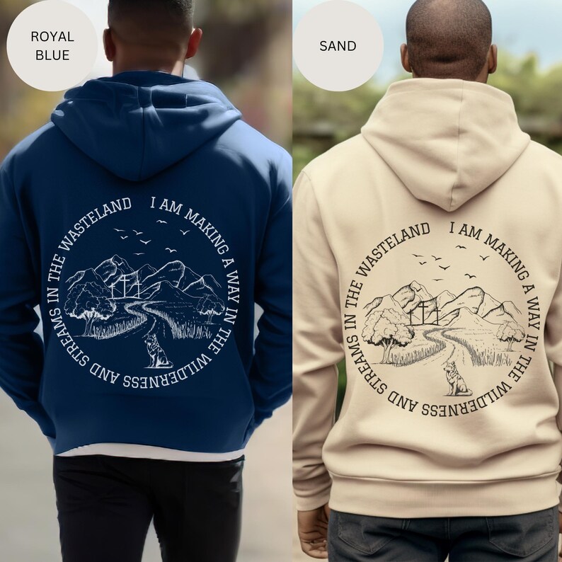 May include: A navy blue and a beige hoodie with a white graphic print on the back. The graphic features a mountain landscape with a winding path, trees, and a wolf. The text on the graphic reads "I am making a way in the wilderness and streams in the wasteland."