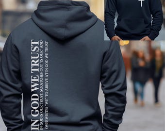 May include: A navy blue hoodie with a white print on the back that reads "IN GOD WE TRUST" and a smaller print that reads "IN GOD IS OUR TRUST, SCRATCHES OUT "IS OUR" AND OVERWRITES "WE" TO ARRIVE AT IN GOD WE TRUST".