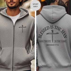 May include: Sport grey zip-up hoodie with a cross design on the front and back. The back of the hoodie features the text "Blessed is the man who trusts in the Lord" and the Bible verse Jeremiah 17:7-8.