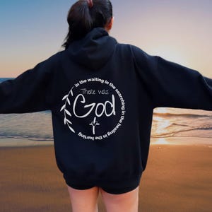 May include: Black hooded sweatshirt with a white graphic print on the back. The graphic features a cross, leaves, and the text "There was God in the waiting in the searching in the healing in the hurting."