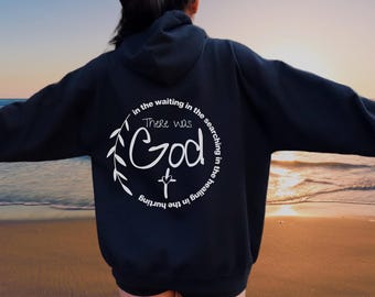 May include: Black hooded sweatshirt with a white graphic print on the back. The graphic features a cross, leaves, and the text "There was God in the waiting in the searching in the healing in the hurting."