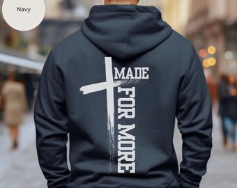 May include: A navy blue hoodie with a white cross and the text "MADE FOR MORE" printed on the back.