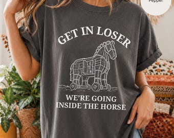 Könnte beinhalten: Ein anthrazitfarbenes Kurzarm-T-Shirt mit einer weißen Strichzeichnung eines Trojanischen Pferdes mit geöffneter Seitenwand. Der Text über dem Pferd lautet GET IN LOSER und der Text darunter WE'RE GOING INSIDE THE HORSE in weißer Schrift.