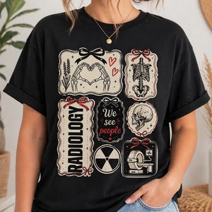 May include: Black t-shirt featuring various medical-themed graphics. Designs include a skeleton forming a heart, a rib cage, a skull, and a CT scanner. The shirt also has the text "RADIOLOGY" and "We see people".
