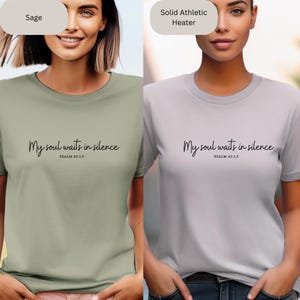 Op de afbeelding: Twee T-shirts met de tekst "My soul waits in silence" en "PSALM 62:1.5" erop gedrukt. Een T-shirt is saliegroen en de andere is lichtgrijs.
