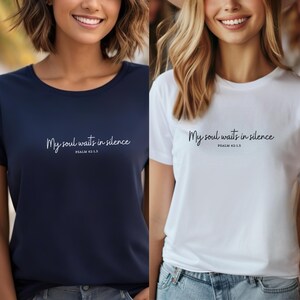 Op de afbeelding: Twee vrouwen dragen T-shirts met de tekst "My soul waits in silence" en de bijbelverwijzing "Psalm 62:1.5". E&eacute;n shirt is donkerblauw en de andere is wit.