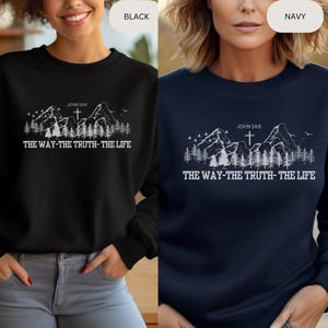 May include: A black and navy blue sweatshirt with a white graphic of mountains, a cross, and the text "JOHN 14:6 THE WAY-THE TRUTH-THE LIFE".