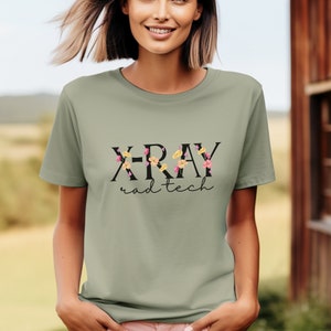 May include: A light green t-shirt with a floral design and the text "X-RAY rad tech" in black.