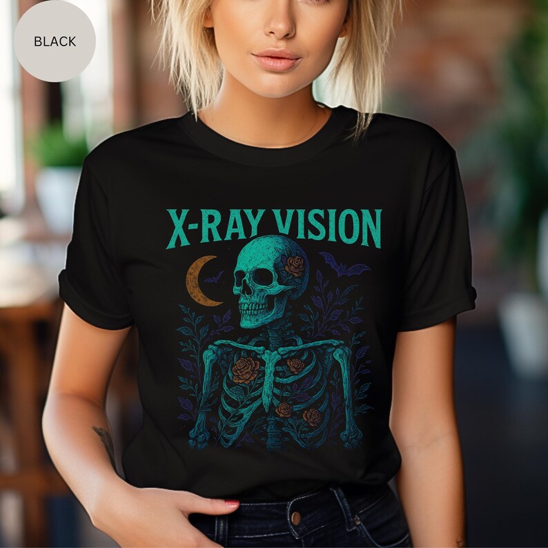 May include: Black t-shirt with a teal skeleton graphic. The skeleton has roses and is surrounded by leaves and bats. The text "X-RAY VISION" is above the skeleton in teal.