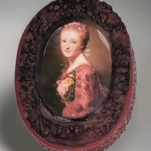 Puede incluir: Retrato ovalado de una mujer con vestido rojo, adornado con flores, enmarcado en un marco rojo oscuro y ornamentado. El marco presenta un diseño floral texturizado, realzando la estética antigua de la obra de arte.