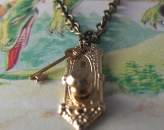 Stop peeping through those keyholes. A miniature, brass, key hole, and lock necklace.
