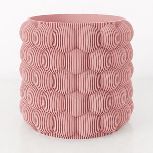 Può includere: Un vaso rosa dal design unico. Il vaso ha una forma cilindrica con una serie di forme a bolla impilate. Ogni forma è composta da linee verticali e parallele, creando una superficie strutturata. Il vaso è realizzato in un materiale rosa chiaro.