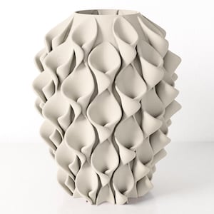 Può includere: Un vaso decorativo color crema con un design unico e strutturato. Il vaso presenta una serie di forme sovrapposte a forma di petalo che creano un effetto scultoreo a strati. Il vaso ha una base ampia e un'apertura più stretta nella parte superiore.