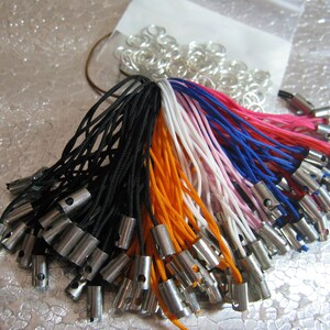 May include: A collection of colorful string cords with metal tips. The cords are arranged in a fan shape and are ready to be used for crafting projects.
