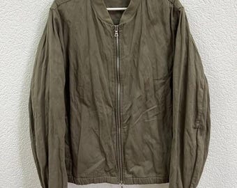 Auténtica chaqueta bomber PRADA con etiqueta roja, una pieza rara fabricada en Italia. Talla L para hombre. Estilo urbano informal de lujo, confeccionada en algodón verde.
